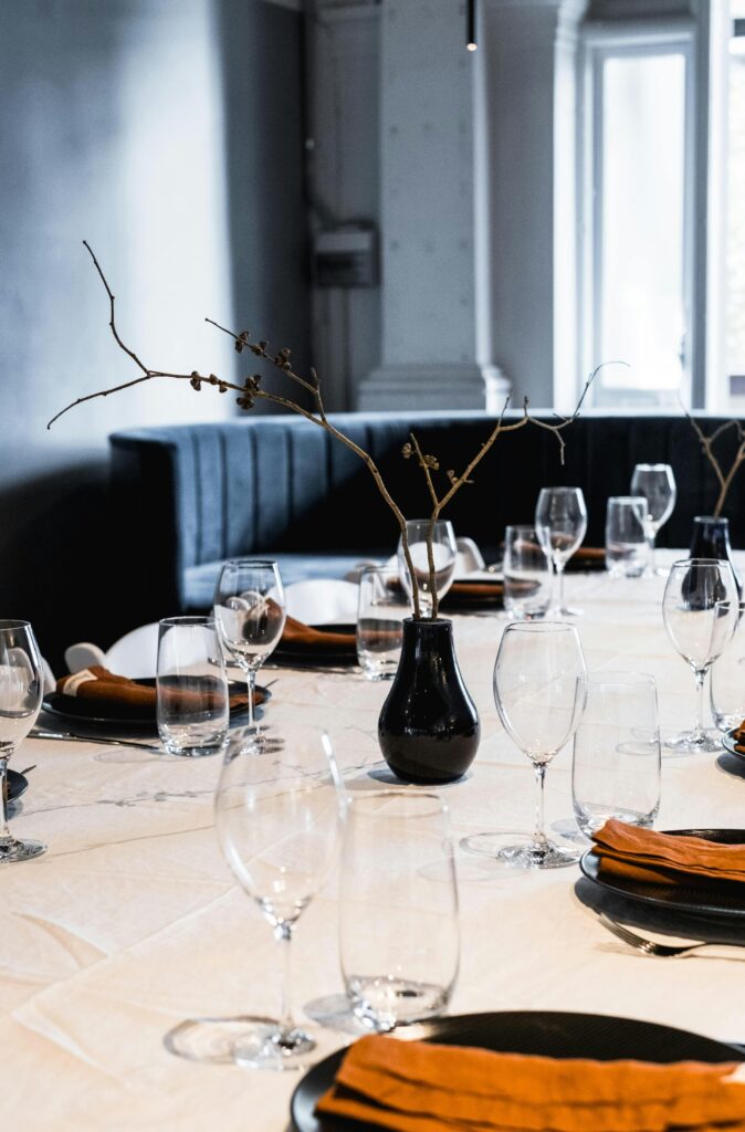 Elegant minimalist table setup with glasses, plates, and centerpiece.